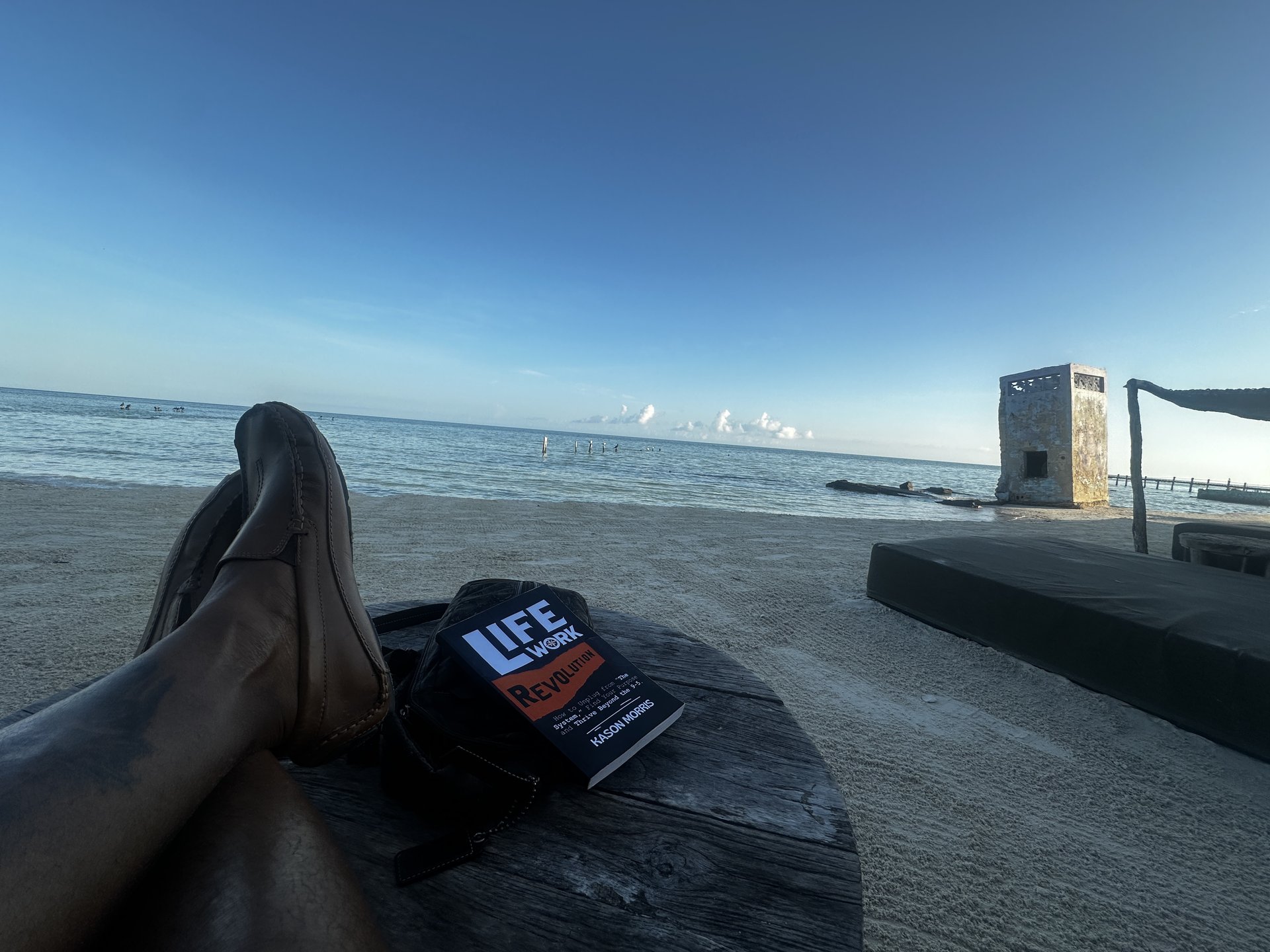 Life Work Revolution by Kason Morris on a beach table by the sea